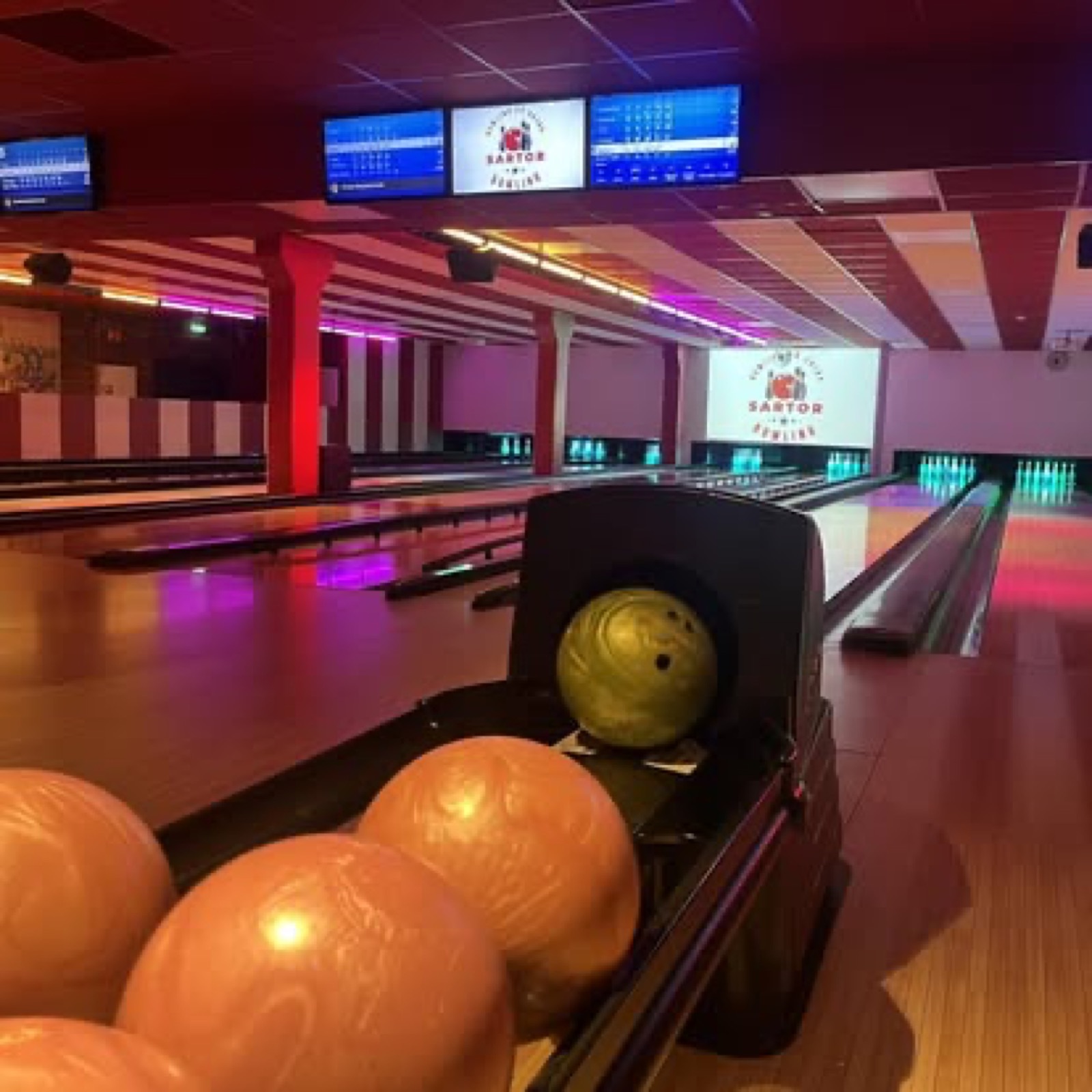 Bowlinghallen om kvelden — LED-stripe over banen og varmt lys fra Pøbben i bakgrunnen